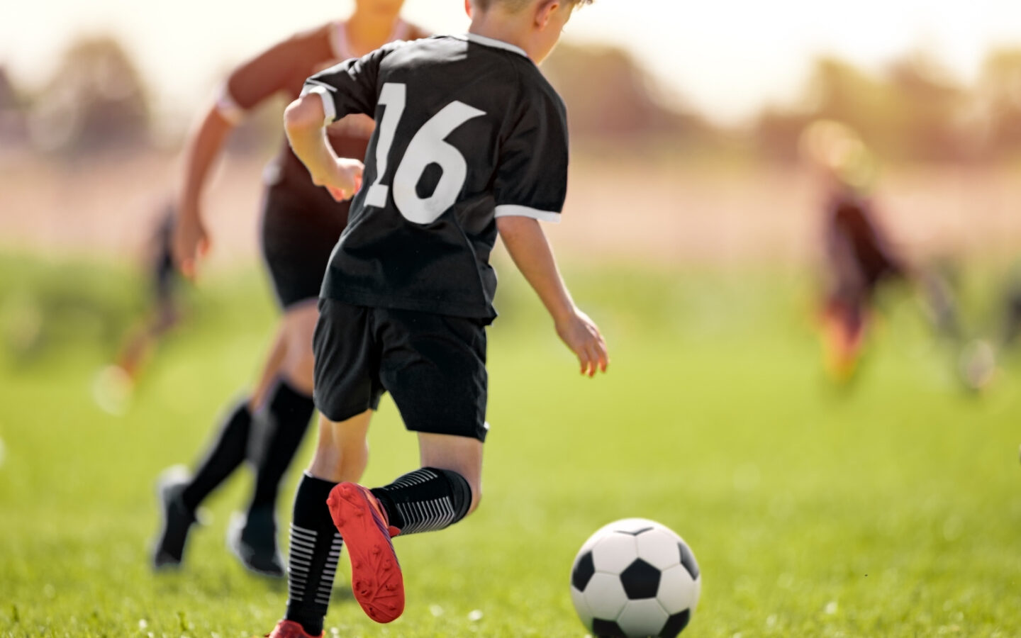 bambino gioca a calcio in età di sviluppo